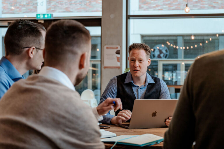 Een team werkt aan een op maat gemaakte website, met een responsive design op laptops en smartphones.